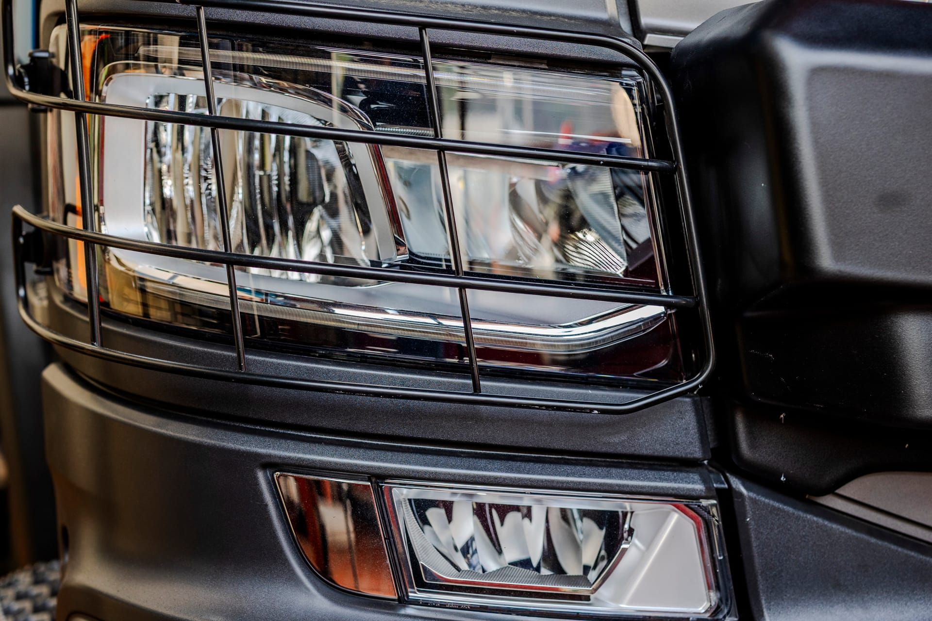 Headlight with protective grille on a municipal vehicle